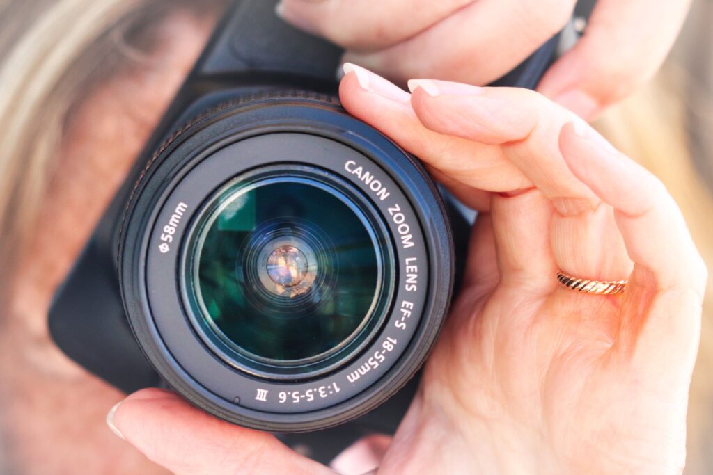 Close-up view of a person holding a camera lens, focusing on photography.