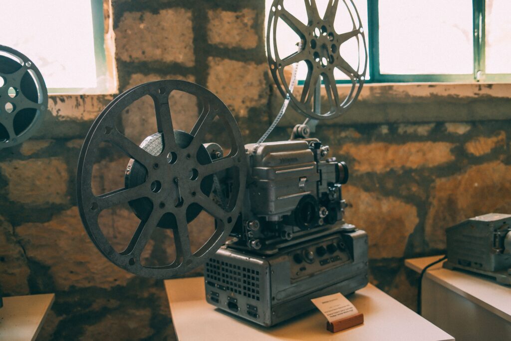 Classic vintage film projector displayed in a rustic indoor setting. Perfect for cinema enthusiasts.
